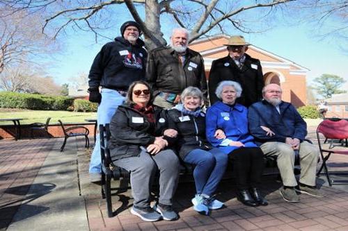 Group of alumni pose at Caswell Plaza